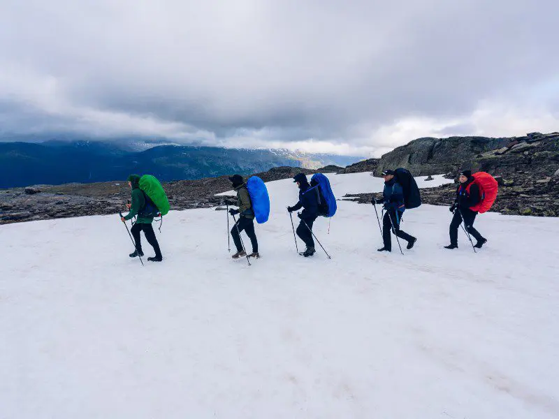 een groep wandelaars die over sneeuw loopt