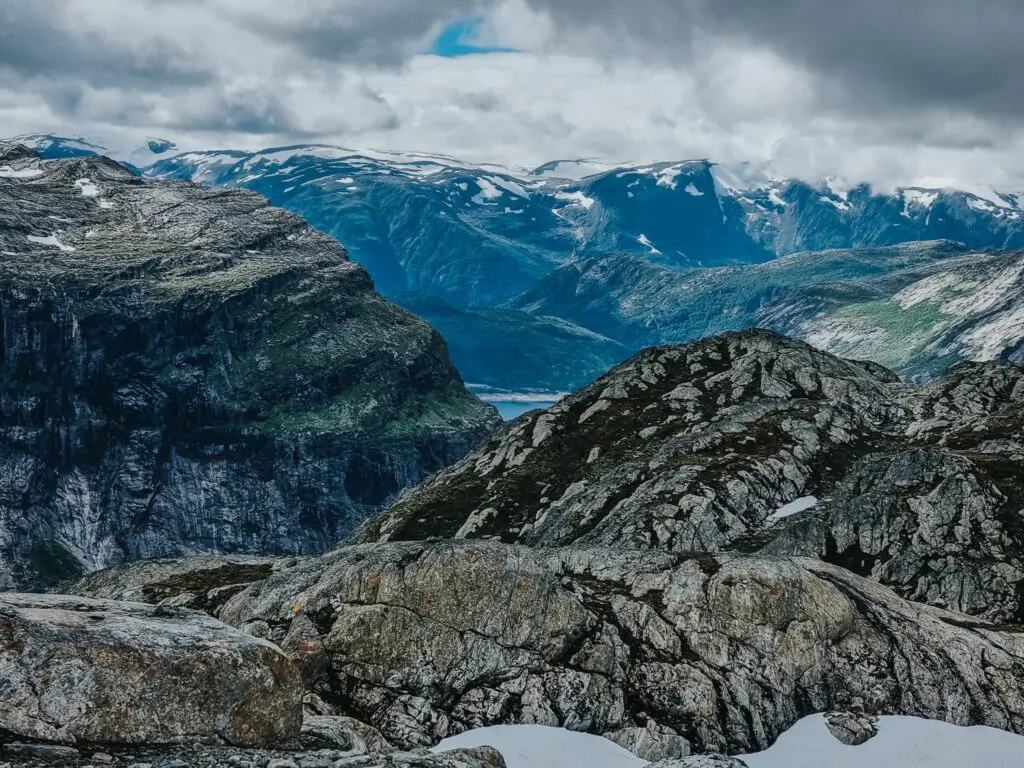 rugged norwegian mountain landscape with snow and distant fjord