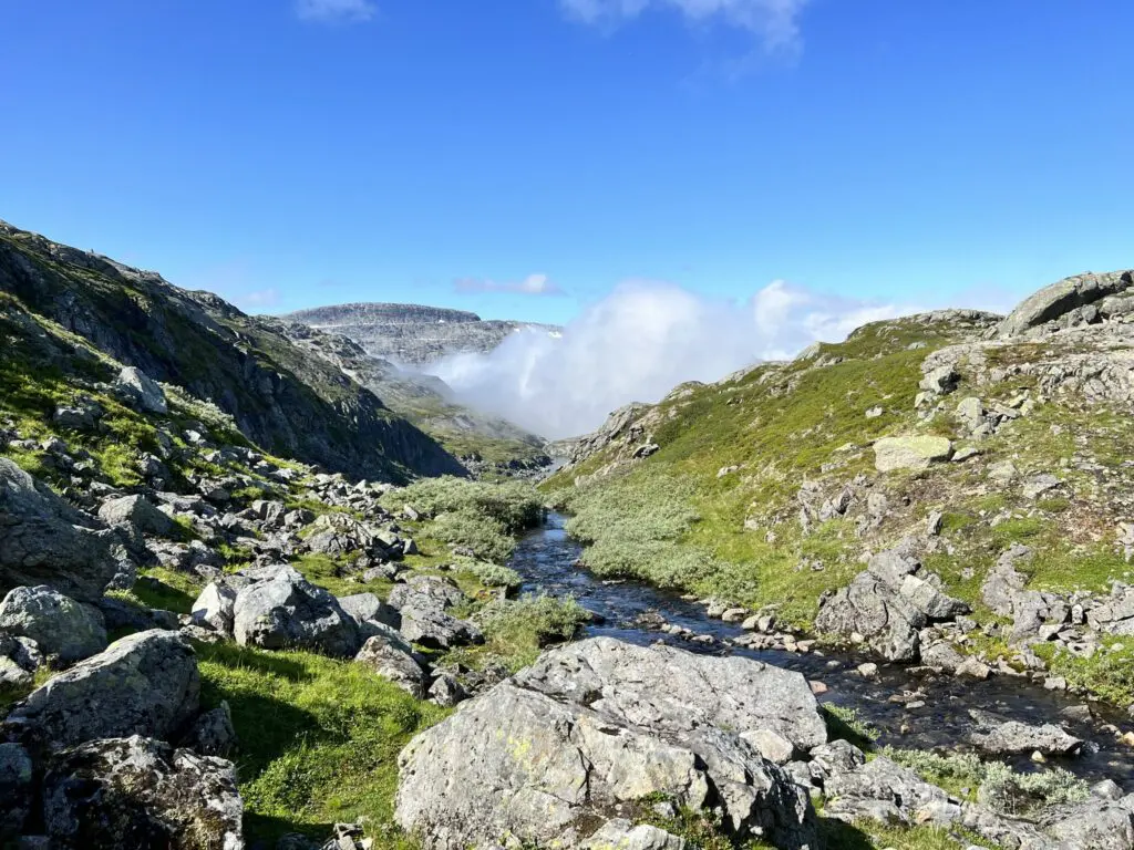 rocky mountain landscape with stream and low clouds