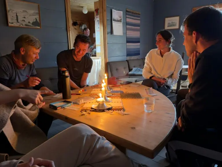 group of friends playing board games by candlelight in a cozy cabin