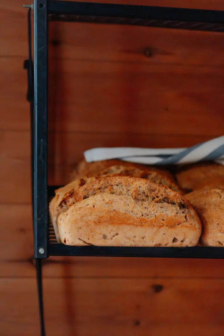freshly baked bread loaves on a shelf with wooden background