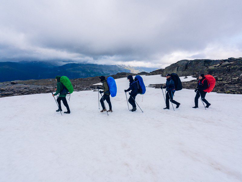 een groep wandelaars die over sneeuw loopt